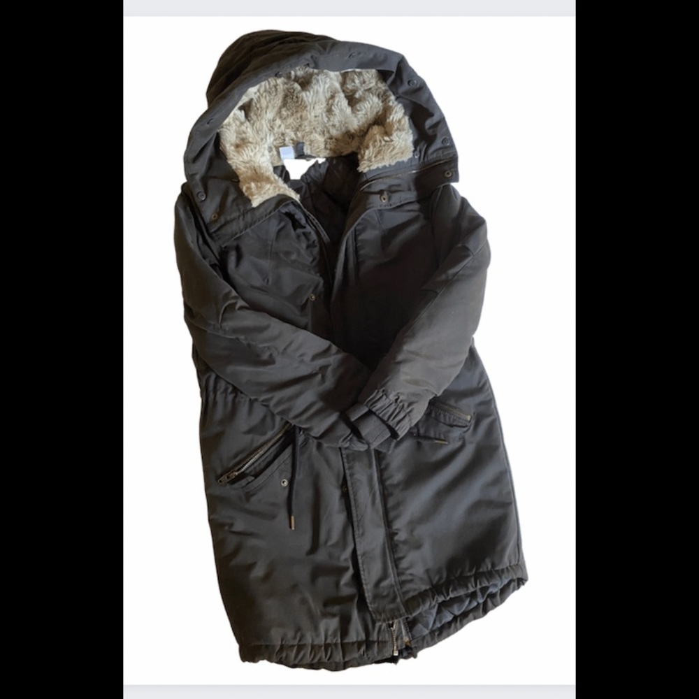 Fitted coat. Zipper at front, side pockets with zipper, long sleeves with cuffs.